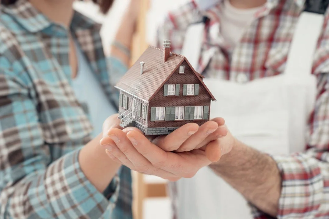Hands holding a model home