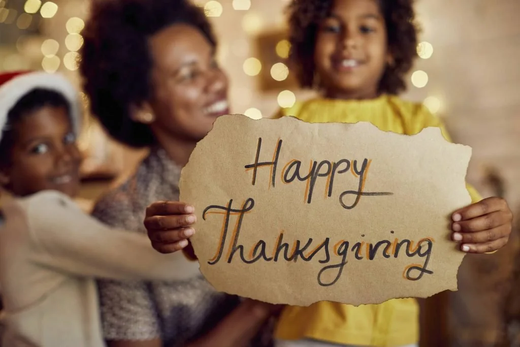 Family holding a Happy Thanksgiving sign