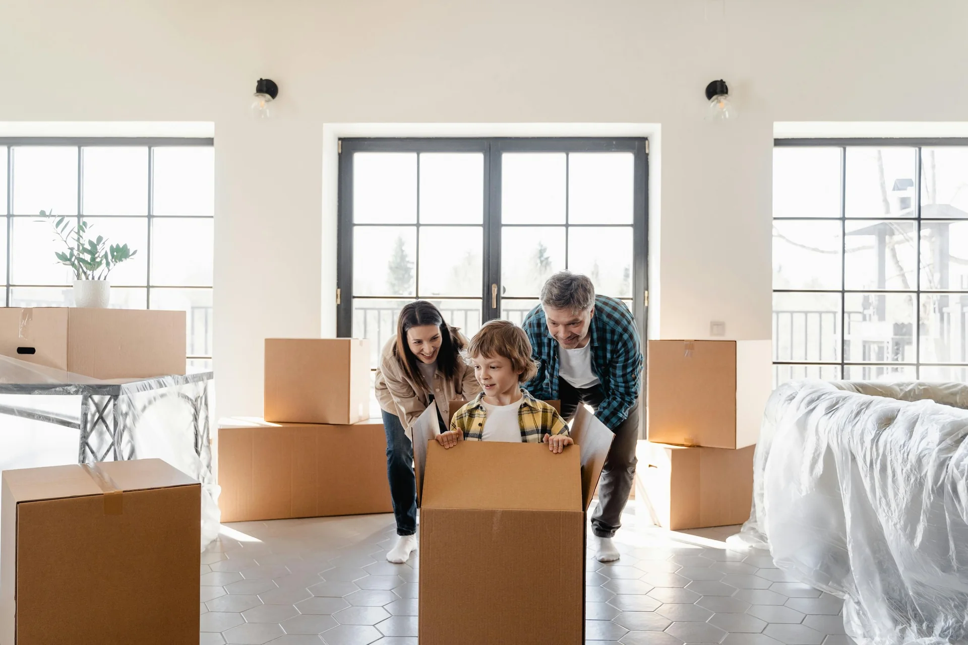 Family unpacking moving boxes in their new home