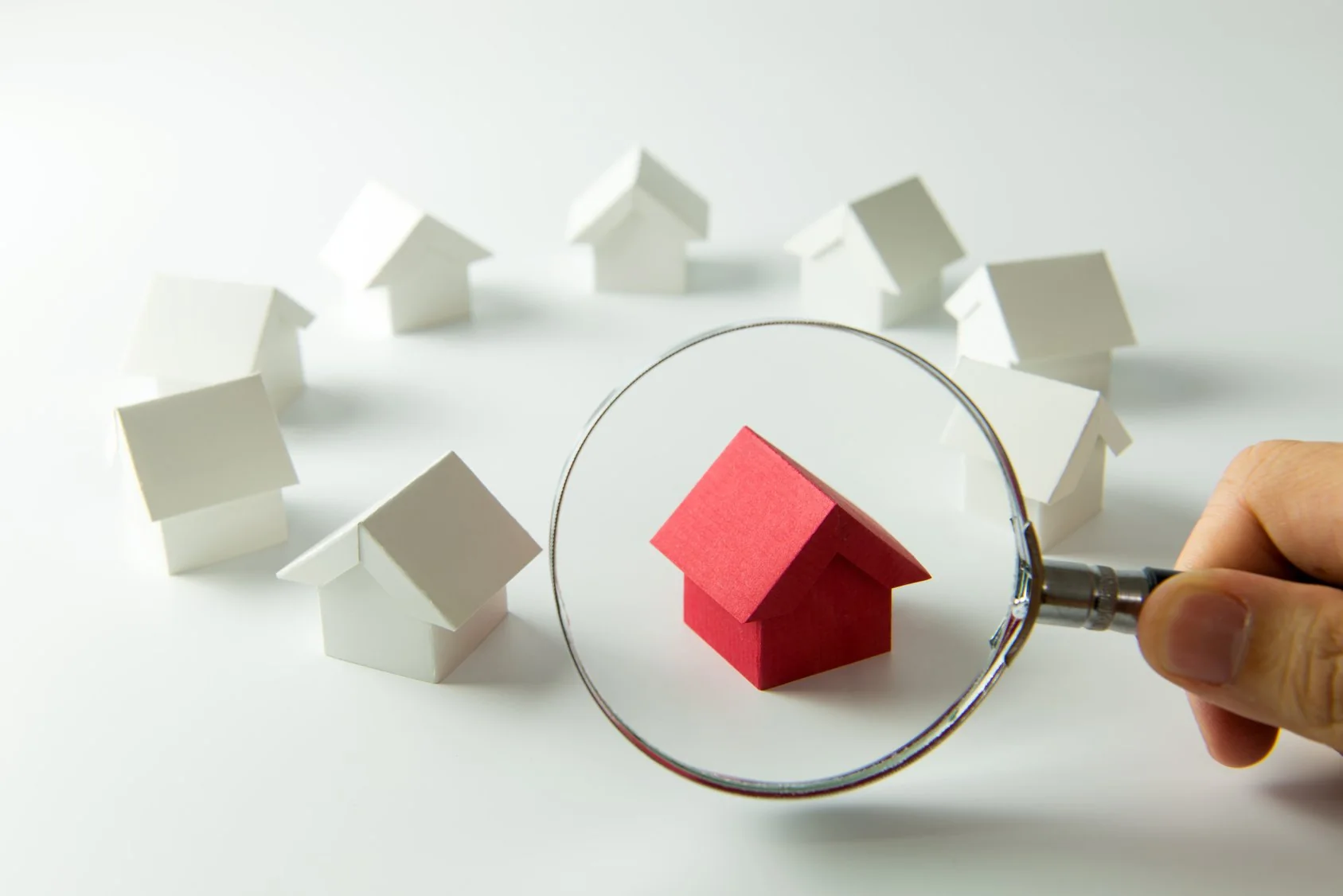 Model home under a magnifying glass