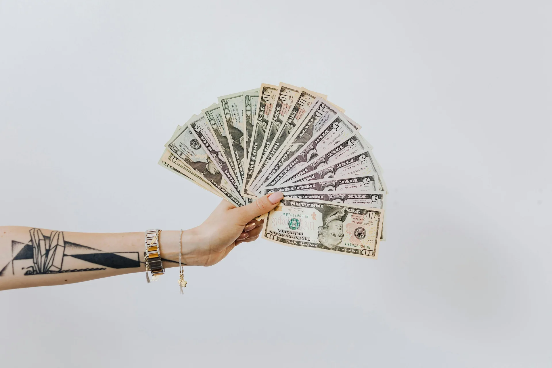 Hand holding a fan of dollar bills