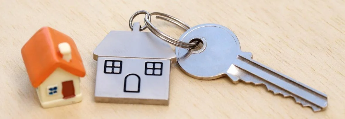 House-shaped key rings beside a key